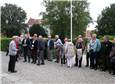 Deltagere ved flagstangen lytter til Kloster forvalteren
