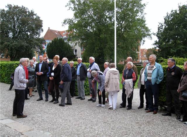 Deltagere ved flagstangen lytter til Kloster forvalteren